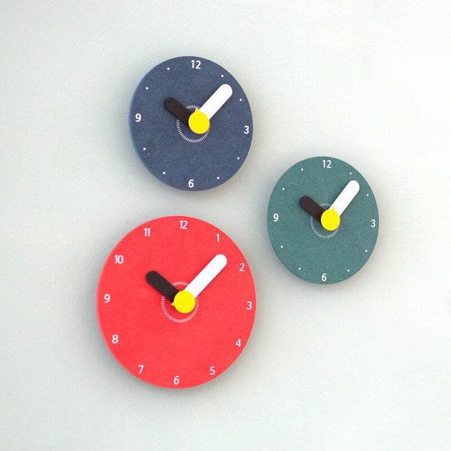 Puinen seinäkello suurilla pyöristetyillä osoittimilla