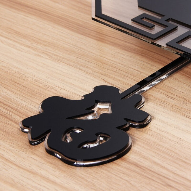 Musta kuusikulmainen seinäkello heilurilla