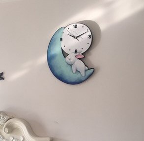 Seinäkello kuussa nukkuvalla kanilla