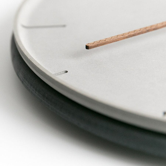 Minimalistinen harmaa seinäkello kupariviisareilla